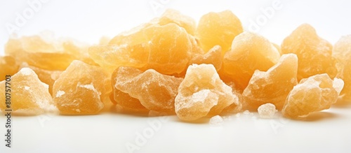 A macro photo of crystallized ginger with a shallow depth of field on a white background providing copy space photo