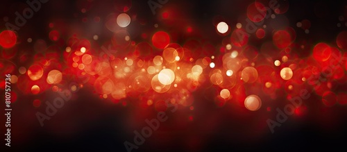 A dark background with red bokeh abstractly blurs circle lights providing a copy space image perfect for adding text photo