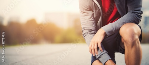 Image of a young man wincing in discomfort due to knee pain creating a copy space image photo