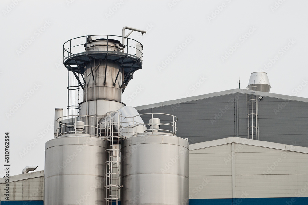 elements of a dairy factory against a background of gray sky elements of a dairy factory against a background of gray sky
