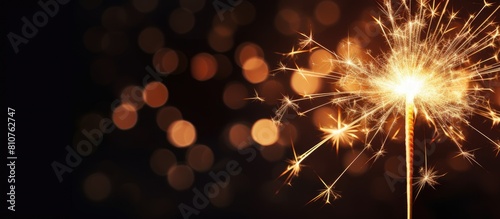 A festive sparkler illuminates a black background setting the scene for a Christmas and New Year s party Copy space image