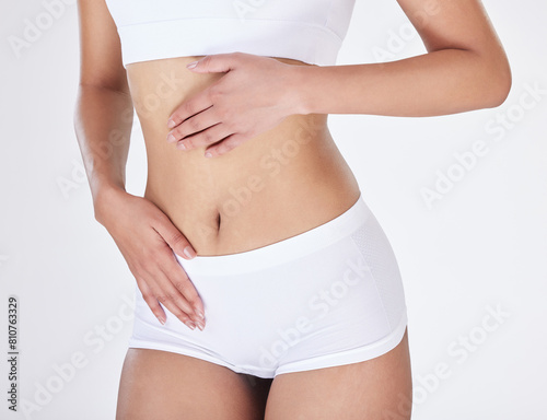 Closeup, stomach and woman with underwear, wellness and fitness on white studio background. Person, girl and model with body, training and exercise with gut health, beauty and workout with balance