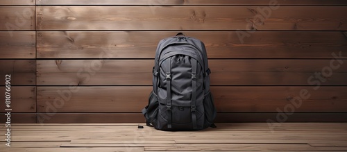 A copy space image of a backpack in a shade of grey placed against a wooden background