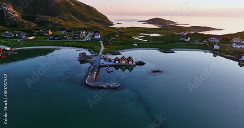 Drone approaching colorful rorbuer at a pier, midnight sun in North Norway photo