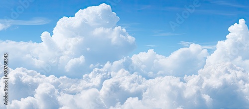 A copy space image of fluffy white clouds against a vivid blue sky