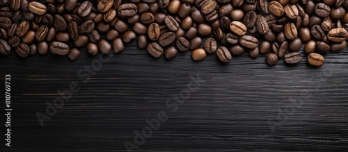 A top view of a coffee bean resting on a black wooden floor with a background suitable for adding text. Creative banner. Copyspace image