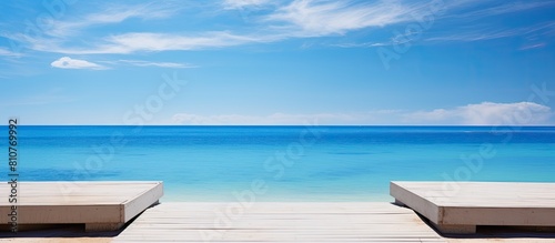 A copy space image of stainless steel steps on a wooden jetty or pier providing a serene view of a tranquil blue ocean portraying the essence of summer vacation or sports photo