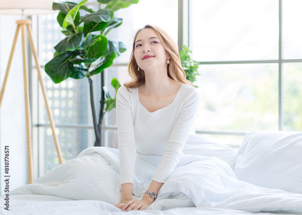 Asian beautiful woman in her bedroom on bed, feeling happy and smiling relaxed stretching arm and body after getting up from sleep on bed in bedroom at home, waking up in the morning. Asian beautiful woman in her bedroom on bed, feeling happy and smiling relaxed stretching arm and body after getting up from sleep on bed in bedroom at home, waking up in the morning.