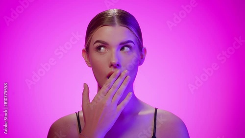 Woman covers her mouth with hand in shock, facial expression disbelieve photo