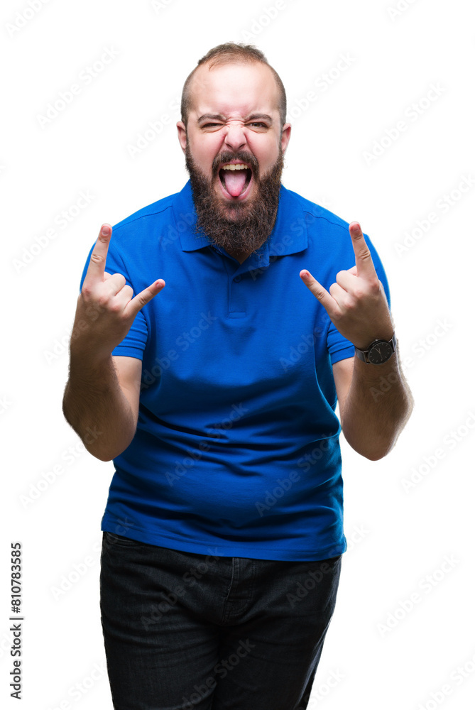 Young caucasian hipster man wearing blue shirt over isolated background shouting with crazy expression doing rock symbol with hands up. Music star. Heavy concept. Young caucasian hipster man wearing blue shirt over isolated background shouting with crazy expression doing rock symbol with hands up. Music star. Heavy concept.