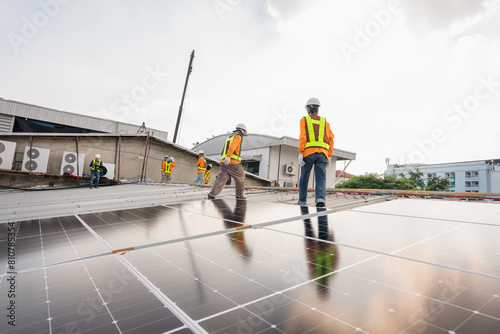 Wallpaper Mural Men technicians carrying photovoltaic solar moduls on roof of factory on the morning. Installing a Solar Cell on a Roof. Solar panels on roof. Workers installing solar cell power plant eco technology. Torontodigital.ca