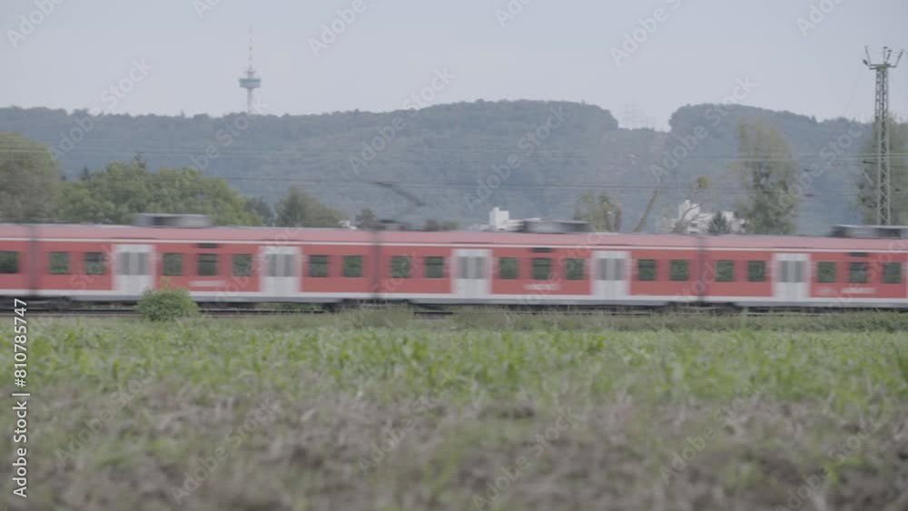 Red Deutsche Bahn Regio train moving swiftly through green fields on a cloudy day, slight motion blur Red Deutsche Bahn Regio train moving swiftly through green fields on a cloudy day, slight motion blur