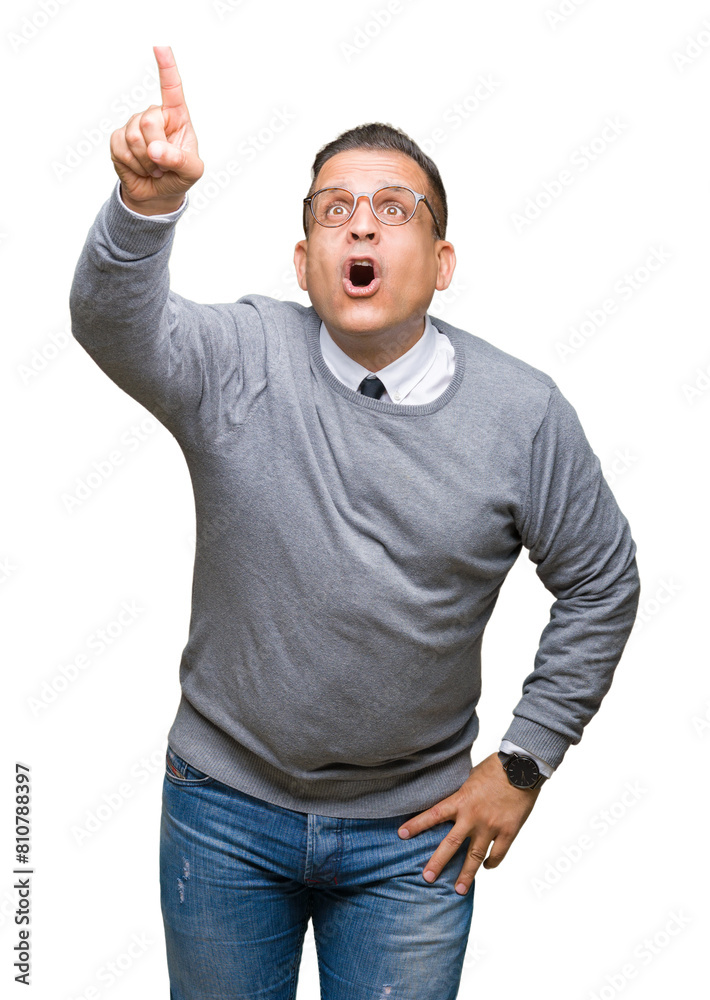 Fototapeta premium Middle age bussines arab man wearing glasses over isolated background Pointing with finger surprised ahead, open mouth amazed expression, something in front