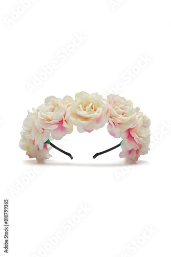 Close-up shot of a handmade plastic hairband decorated with light pink roses. The bright floral wreath for head is isolated on a white background. Front view.