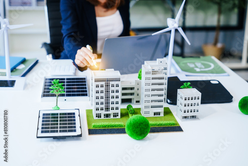 Close up Middle Aged Asian woman works at her desk, championing sustainability reducing carbon footprint, promoting renewables, conserving water, minimizing waste, embracing eco-friendly practices.