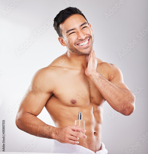 Happy, man and perfume in studio with skincare or grooming for self care, wellness and natural cosmetics for face. Person, isolated and white background with fragrance cologne for aftershave routine.