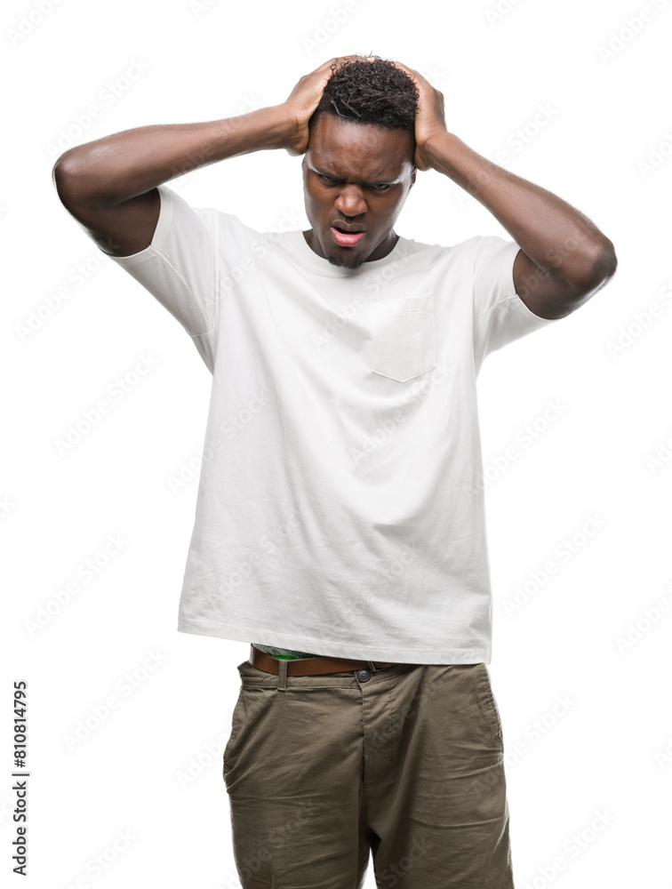 Young african american man wearing white t-shirt suffering from headache desperate and stressed because pain and migraine. Hands on head. Young african american man wearing white t-shirt suffering from headache desperate and stressed because pain and migraine. Hands on head.