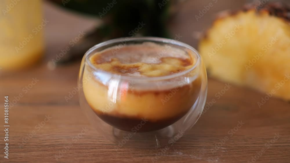 Exotic fresh pineapple puree with espresso coffee drink in double-bottom transparent glass