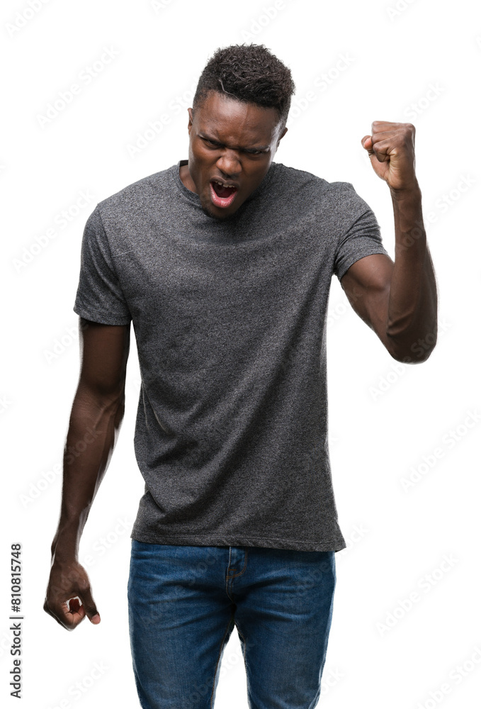 Young african american man wearing grey t-shirt angry and mad raising fist frustrated and furious while shouting with anger. Rage and aggressive concept. Young african american man wearing grey t-shirt angry and mad raising fist frustrated and furious while shouting with anger. Rage and aggressive concept.