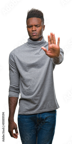 Young african american man over isolated background doing stop sing with palm of the hand. Warning expression with negative and serious gesture on the face.