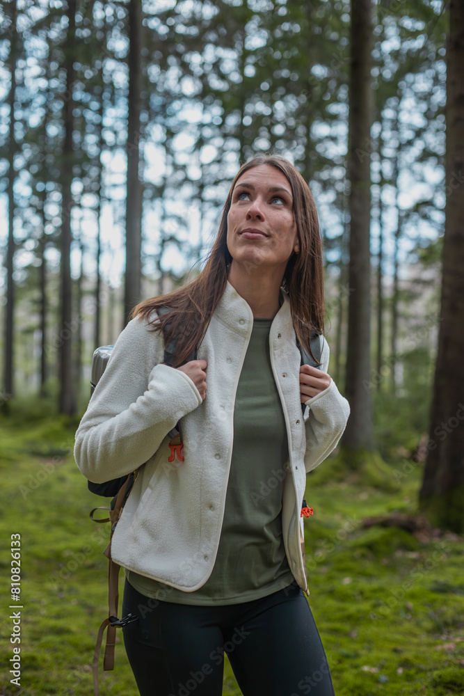 Beautiful young explorer woman enjoying the view during a hike in the forest in spring Beautiful young explorer woman enjoying the view during a hike in the forest in spring