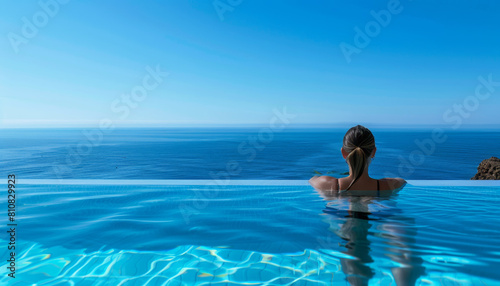 Donna che nuota in una piscina di una spa dell'hotel di lusso con vista sul mare