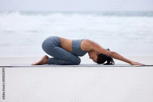 Obraz Yogi, stretching and mat on beach for yoga, fitness and wellness for exercise or pilates for workout. Active lady, zen and training on ocean for outdoor recreation, mental health and peace on mockup