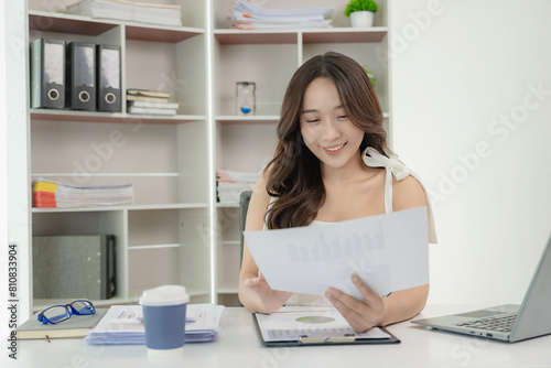 Free Download Happy young Asian employee sitting at table and working with computer and calculator, financial documents Calculate the legal company's tax rate financial accounts on the computer. - GFXLoad