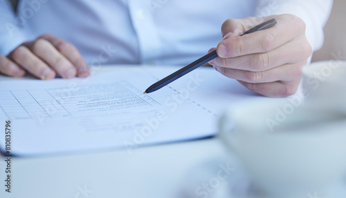 Hand, medical paperwork and pen at desk for information, report or history with planning for wellness. Person, documents and writing with checklist, decision and legal contract for health in hospital photo