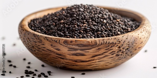Dark sesame seeds in rustic bowl on blank backdrop with clear focus.