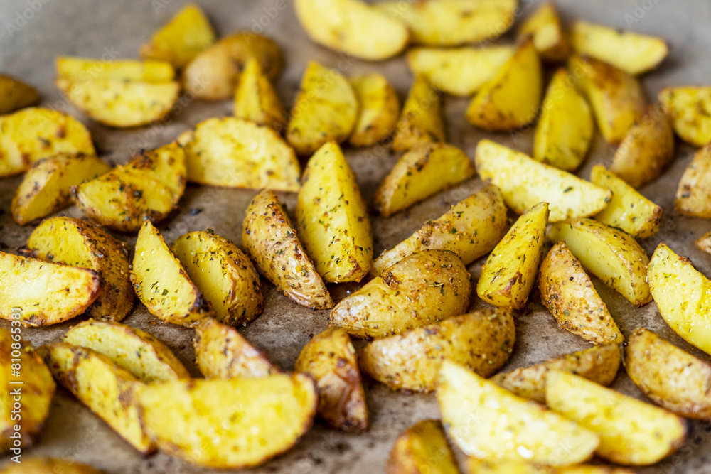 Appetizing baked potato slices with spices, close up