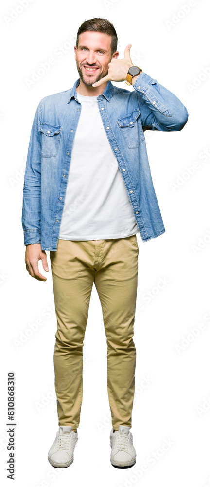 Handsome man with blue eyes and beard wearing denim jacket smiling doing phone gesture with hand and fingers like talking on the telephone. Communicating concepts. Handsome man with blue eyes and beard wearing denim jacket smiling doing phone gesture with hand and fingers like talking on the telephone. Communicating concepts.