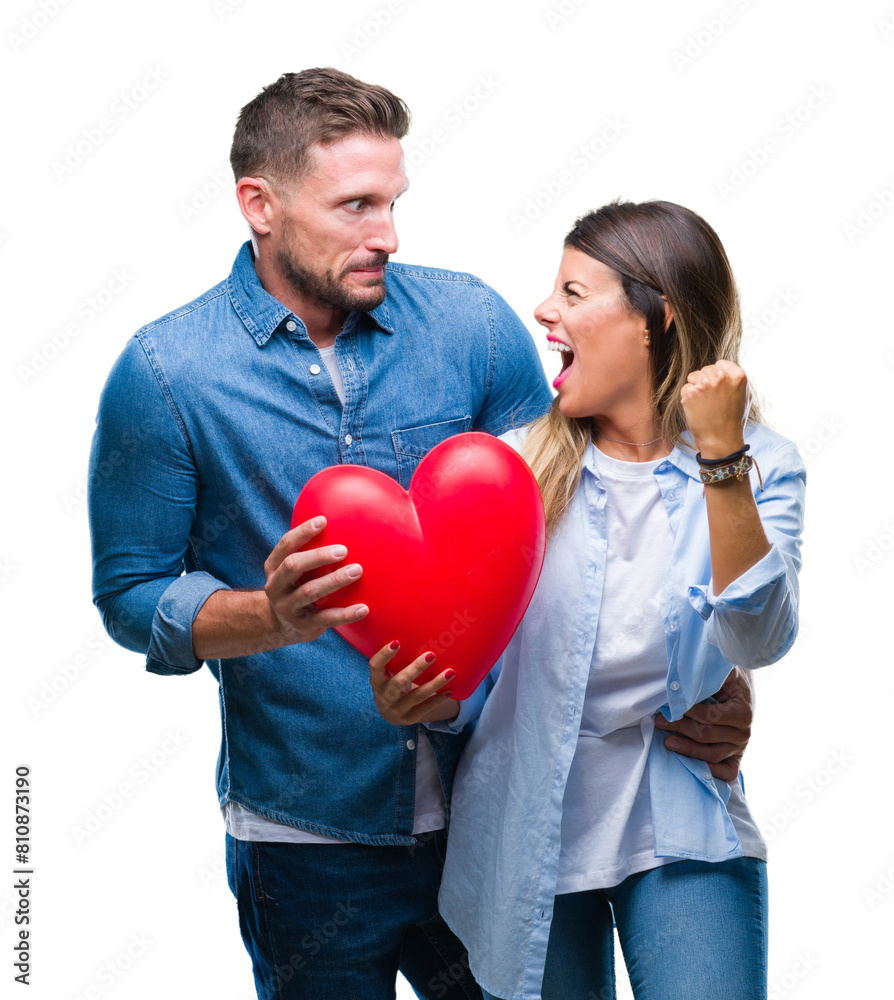 Young couple in love holding red heart over isolated background annoyed and frustrated shouting with anger, crazy and yelling with raised hand, anger concept Young couple in love holding red heart over isolated background annoyed and frustrated shouting with anger, crazy and yelling with raised hand, anger concept