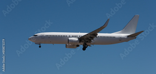 White passenger plane against blue sky just before landing at airport