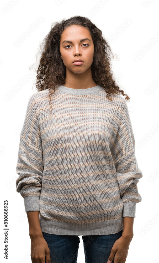 Beautiful young hispanic woman wearing stripes sweater with serious expression on face. Simple and natural looking at the camera. Beautiful young hispanic woman wearing stripes sweater with serious expression on face. Simple and natural looking at the camera.