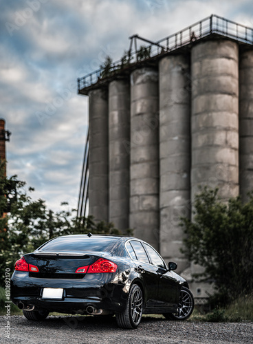 Black car parked in front of silos