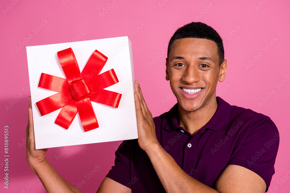 Photo portrait of handsome young guy hold giftbox wear trendy violet outfit isolated on pink color background Photo portrait of handsome young guy hold giftbox wear trendy violet outfit isolated on pink color background