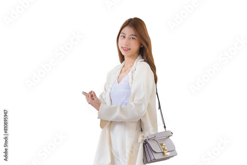 Young professional Asian business female in white suit smiles and holds a smartphone in her hands in happily workday at the city while isolated white background.