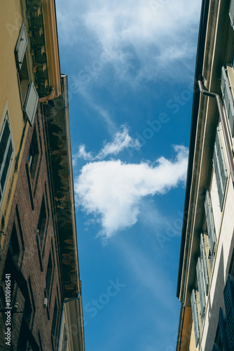 White cloud passing between two buildings in a blue sky