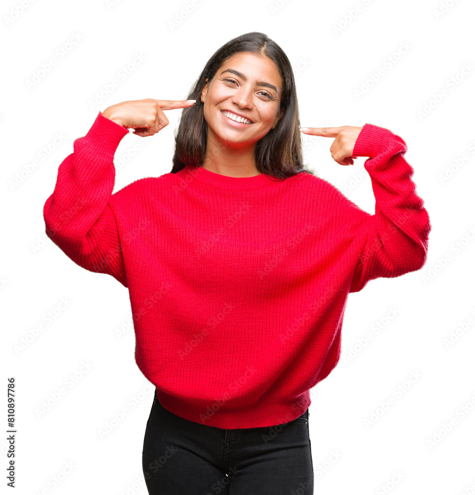 Young beautiful arab woman wearing winter sweater over isolated background smiling confident showing and pointing with fingers teeth and mouth. Health concept. Young beautiful arab woman wearing winter sweater over isolated background smiling confident showing and pointing with fingers teeth and mouth. Health concept.