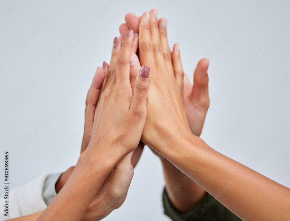 High five, hands together and team of people in studio with unity, collaboration and partnership. Goal, connection and group of friends with celebration gesture for solidarity by gray background. High five, hands together and team of people in studio with unity, collaboration and partnership. Goal, connection and group of friends with celebration gesture for solidarity by gray background.