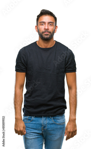 Adult hispanic man over isolated background with serious expression on face. Simple and natural looking at the camera.