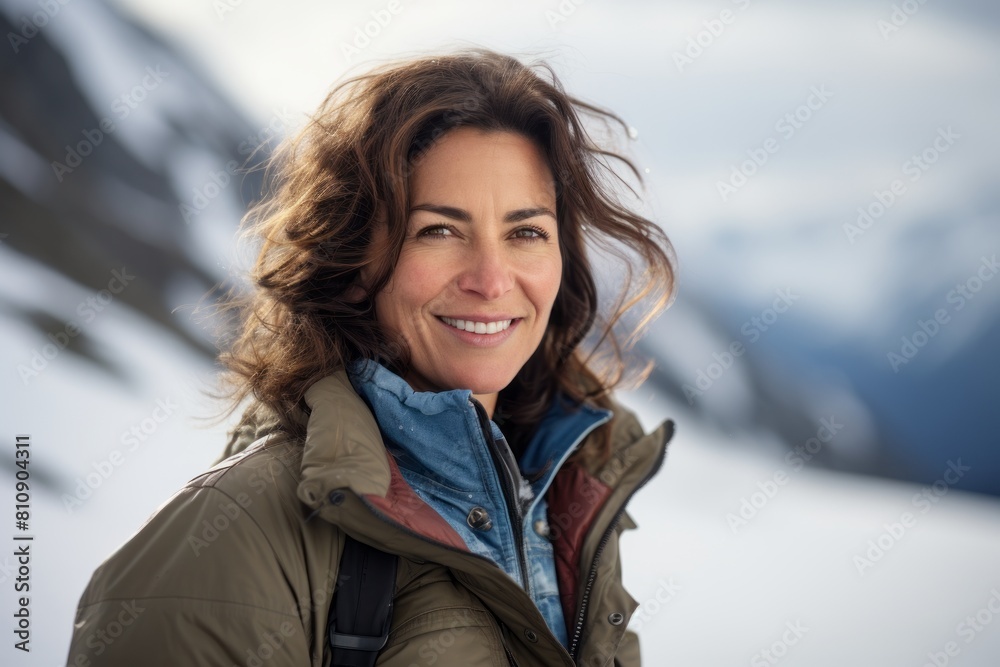 Portrait of a smiling woman in her 40s sporting a rugged denim jacket isolated in pristine snowy mountain Portrait of a smiling woman in her 40s sporting a rugged denim jacket isolated in pristine snowy mountain