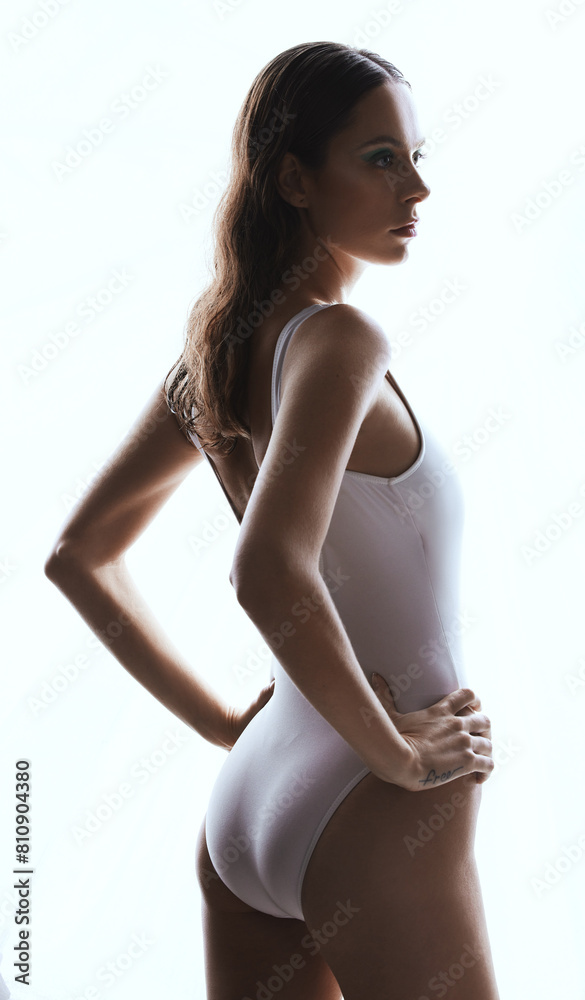 Fototapeta premium Confidence, serious and woman in bodysuit, studio and bikini for summer, aesthetic and clothes to relax. Swimsuit, proud and girl in white background, body and empowerment with fashion of shapewear