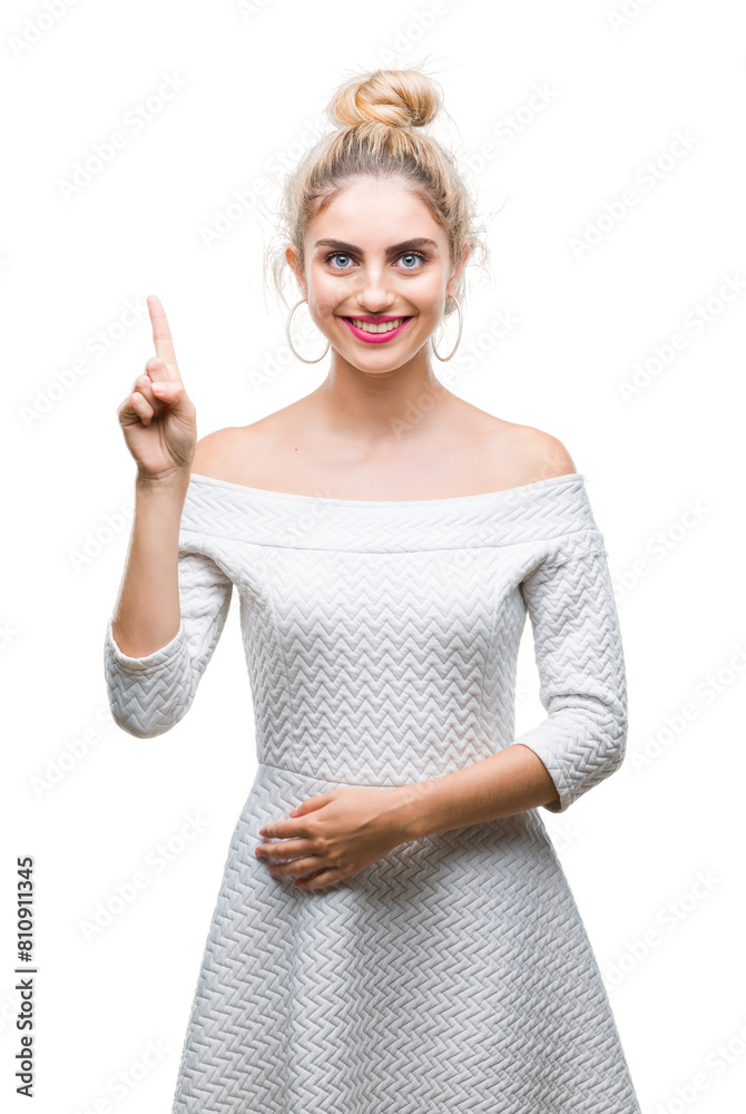 Young beautiful blonde and blue eyes woman over isolated background showing and pointing up with finger number one while smiling confident and happy. Young beautiful blonde and blue eyes woman over isolated background showing and pointing up with finger number one while smiling confident and happy.