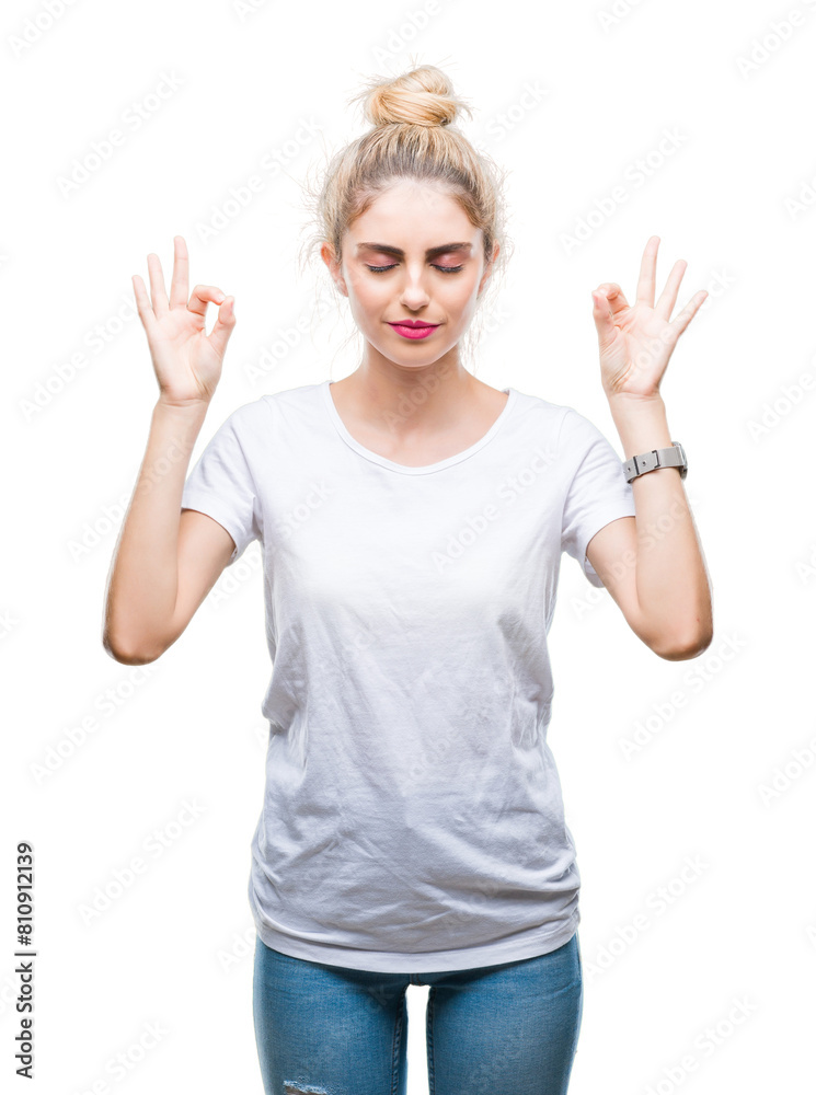 Young beautiful blonde woman wearing white t-shirt over isolated background relax and smiling with eyes closed doing meditation gesture with fingers. Yoga concept. Young beautiful blonde woman wearing white t-shirt over isolated background relax and smiling with eyes closed doing meditation gesture with fingers. Yoga concept.
