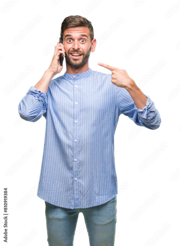 Young handsome man speaking on the phone over isolated background very happy pointing with hand and finger Young handsome man speaking on the phone over isolated background very happy pointing with hand and finger