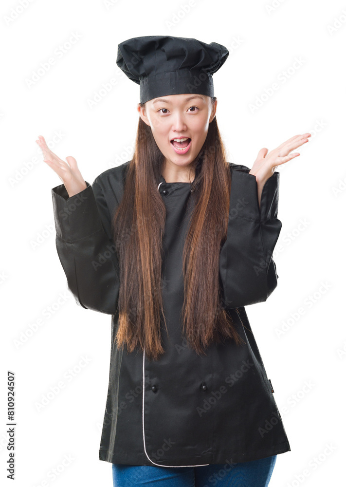 Young Chinese woman over isolated background wearing chef uniform celebrating crazy and amazed for success with arms raised and open eyes screaming excited. Winner concept Young Chinese woman over isolated background wearing chef uniform celebrating crazy and amazed for success with arms raised and open eyes screaming excited. Winner concept