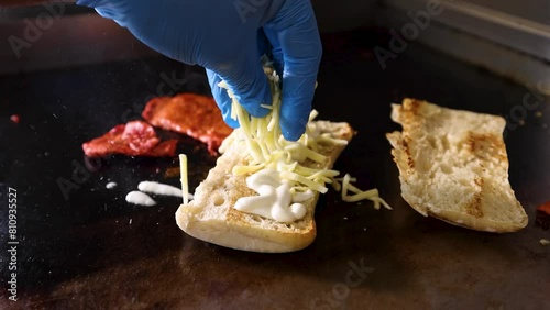 Panini sprinkled with cheese in slow motion and chicken tikka