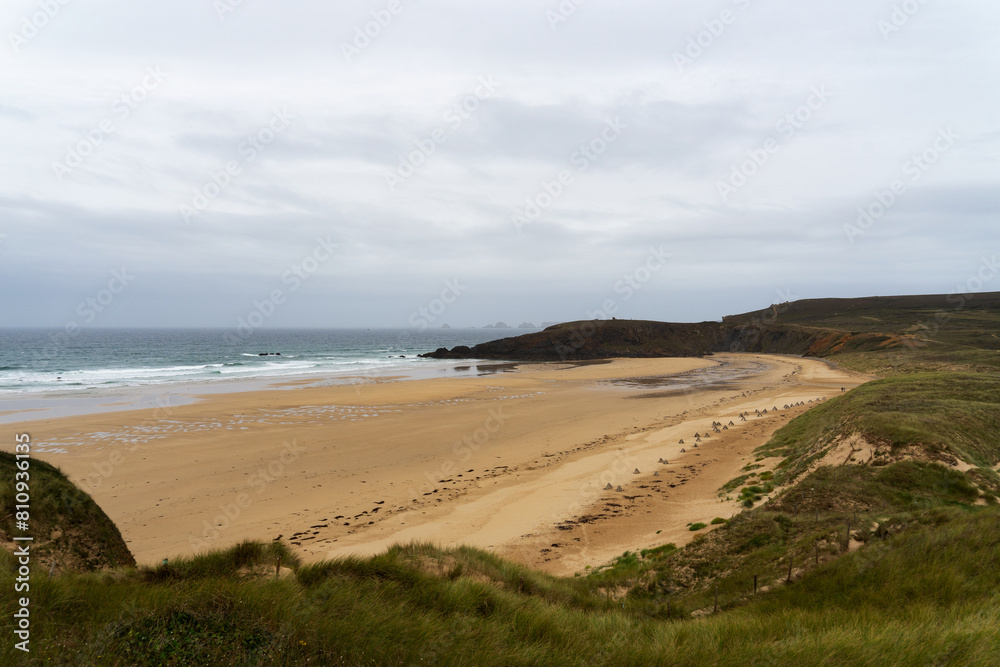 Dunes et tétraèdres sur la plage de Lostmarc'h, vestiges de la Seconde Guerre mondiale, mêlant histoire et beauté naturelle bretonne.